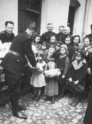 Policjant wydający dzieciom paczki