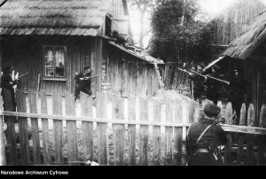 Dom, w którym ukrywają się przestępcy obstawiony przez częstochowskich policjantów. Funkcjonariusze uzbrojeni są w karabiny Mosin wz. 1891.