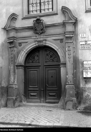 Brama wejściowa i ozdobny portal Pałacu Górków przy ulicy Kanoniczej 24. Z boku widoczne szyldy Komenda Policji Państwowej Wydział Śledczy
