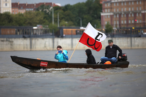 rodzina na łodzi z flagą znaku polski walczącej