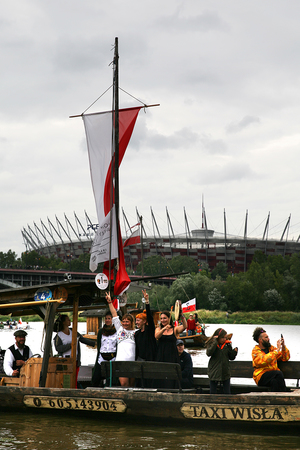 grupa uczestników w flagą polski płynąca na godzinę &quot;w&quot;