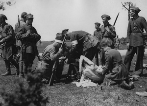 Ćwiczenia oddziału sanitarnego - opatrywanie rannych. Żołnierz klęczący z lewej strony uzbrojony jest w karabin Mannlicher M1895