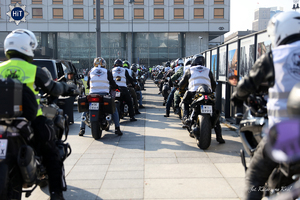 Motocykliści siedzą na swoich motocyklach zaparkowanych w rzędach i przygotowują się do startu.