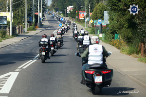 Motocykliści jadą jednym pasem ruchu po szosie poza zabudowaniami miejskimi.