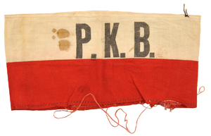 Opaska powstańcza należąca do funkcjonariusz Państwowego Korpusu Bezpieczeństwa Opaska należała do podchorążego Stanisława Adama Floryana, ps. &quot;Szary Adam&quot;, który był członkiem PKB  m. st. Warszawy. Pełnił funkcję zastępcy kierownika I Komisariatu X Obwodu PKB przy ulicy ul. Szpitalnej 7 w Śródmieściu.