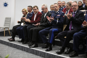 Goście siedzący na widowni biją brawo, wśród nich Komendant Główny Policji gen.ł Marek Boroń.