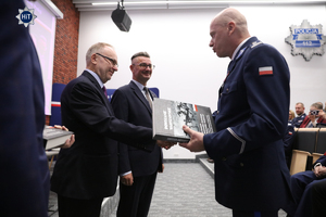 Insp. Robert Horosz otrzymuje gratulacje i książkę od jednego z prelegentów.