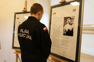 Uczeń klasy mundurowej czyta materiał umieszczony na sztaludze.