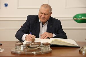 Paweł Skrzecz, bokser, jeden z olimpijczyków wpisuje się do księgi pamiątkowej.