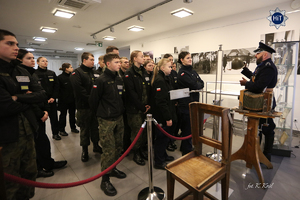 policjant w mundurze policji państwowej opowiada o eksponatach