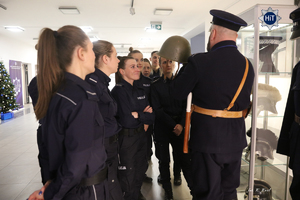 Reprezentantki drużyny w Futsalu słuchają wykładu pracownika Wydziału Edukacji Historycznej ubranego w mundur funkcjonariusza Policji Państwowej.