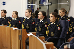 Funkcjonariuszki Straży Marszałkowskiej w galowych mundurach słuchają w skupieniu wystąpienia profesora.