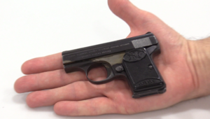 Zdjęcie odwróconej dłoni, na której leży pistolet  Jest on wielkości połowy dłoni.
