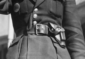 Zdjęcie prezentujące zbliżenie na skórzana kaburę , w której umieszczona jest broń funkcjonariuszki Policji Państwowej.