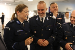 Uśmiechnięci funkcjonariusze Policji stoją w jednaj z sal Wydziału Edukacji Historycznej.