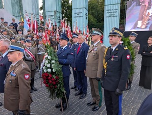 Delegacje różnych służb mundurowych stoją przy Pomniku Powstania Warszawskiego na pL. Krasińskich w Warszawie.