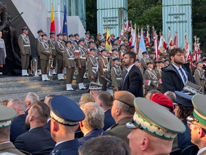 Widok na Orkiestrę Reprezentacyjną Wojska Polskiego, która stoi na stopniach przy Pomniku Powstania Warszawskiego na pl. Krasińskich w Warszawie.