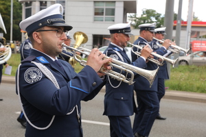 Funkcjonariusze Policji z Reprezentacyjnej Orkiestry grają na instrumentach dętych.