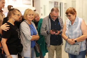 Grupa osób ogląda pistolet będący jednym z eksponatów zgromadzonych w Wydziale Edukacji Historycznej.