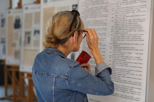 Kobieta czyta informacje tekstowe prezentowane na sztalugach.