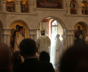 Widok na ołtarz prawosławnej cerkwi. W tle prawosławny duchowny.