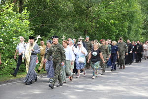 Prawosławni duchowni, żołnierze Wojska Polskiego, Policji, a także pozostali uczestnicy pielgrzymki idą szosą niosąc drewniane prawosławne krzyże.