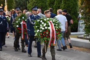 Funkcjonariusze Policji składają wieńce z biało-czerwonych kwiatów pod pomnikiem na Cmentarzu Żołnierzy Poległych 1920 roku