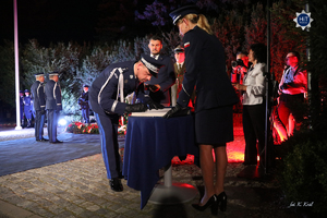 Komendant Główny Policji wpisuje się do księgi pamiątkowej.
