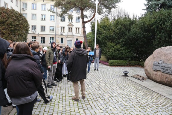 Pracownik Wydziału oprowadza młodzież po Komendzie Głównej Policji.