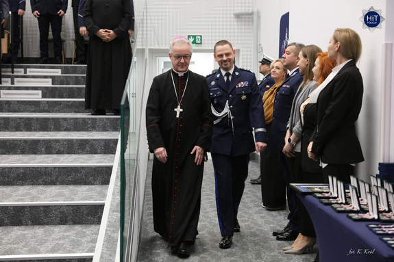 Na salę wchodzi biskup polowy oraz Komendant Główny Policji. Zaproszeni goście powstają ze swoich miejsc.