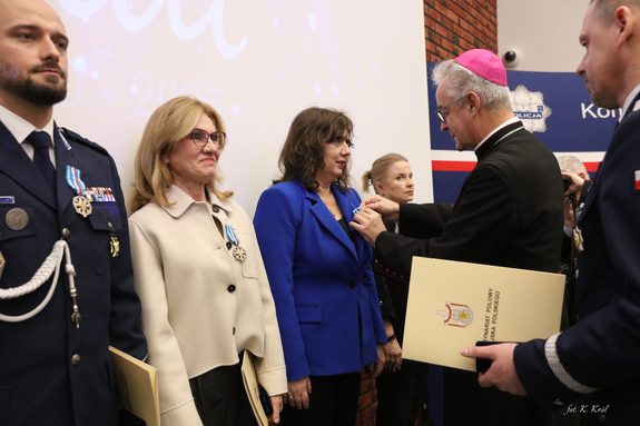 Ksiądz biskup odznacza honorową odznaką pracowników cywilnych.