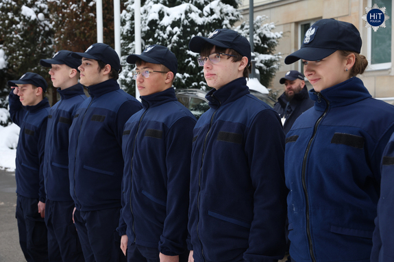 Uczniowie klasy mundurowej stoją na baczność na placu przed gmachem Komendy Głównej Policji