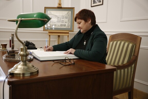 Kobieta wpisuje się do księgi pamiątkowej