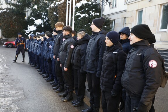 Uczniowie klasy mundurowej stoją w szeregu na placu przed gmachem Komendy Głównej Policji