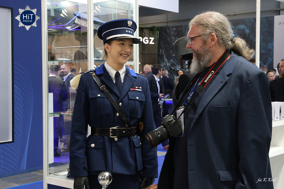Policjantka u umundurowaniu Policji Państwowej rozmawia z fotografem